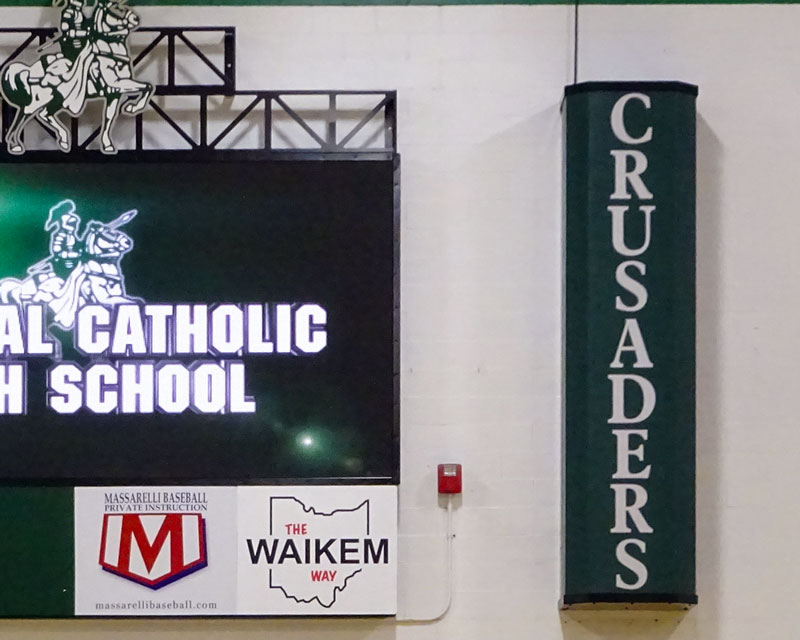 speaker with school logo next to scoreboard